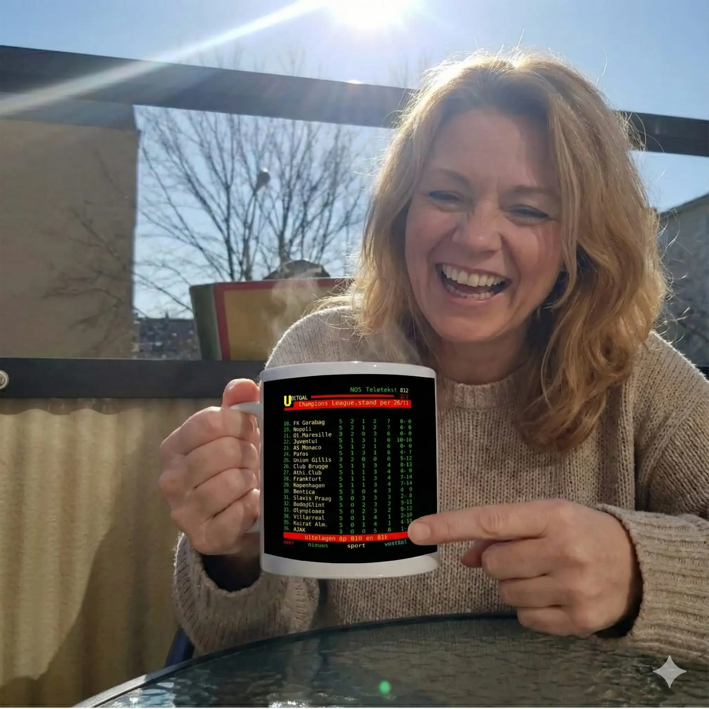 Anti Ajax mok Feyenoord cadeau - vrouw lacht met teletekst Ajax laatste plaats