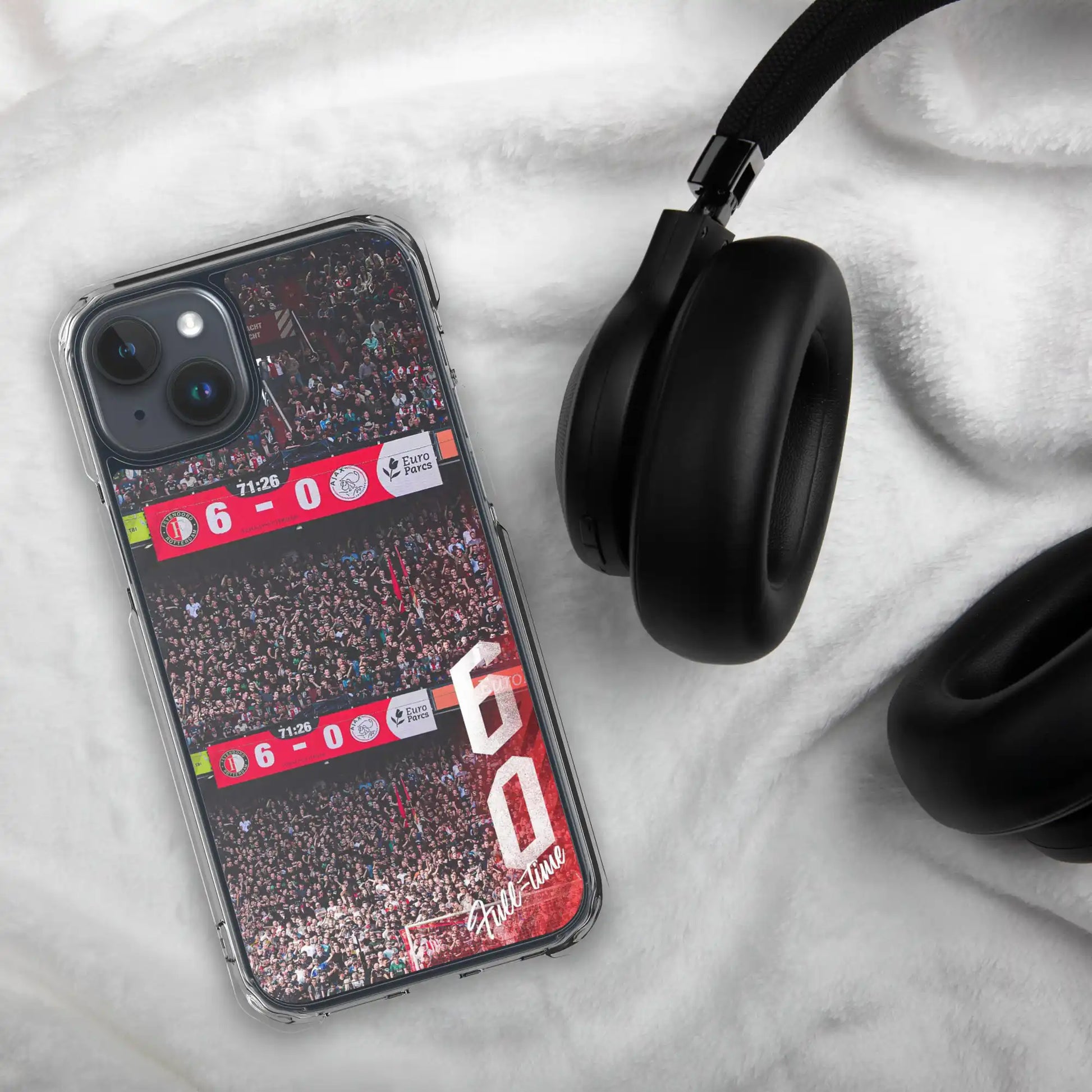 feyenoord-6-0-overwinning-iphone-hoesje-decoratie, liggend op witte deken met koptelefoon