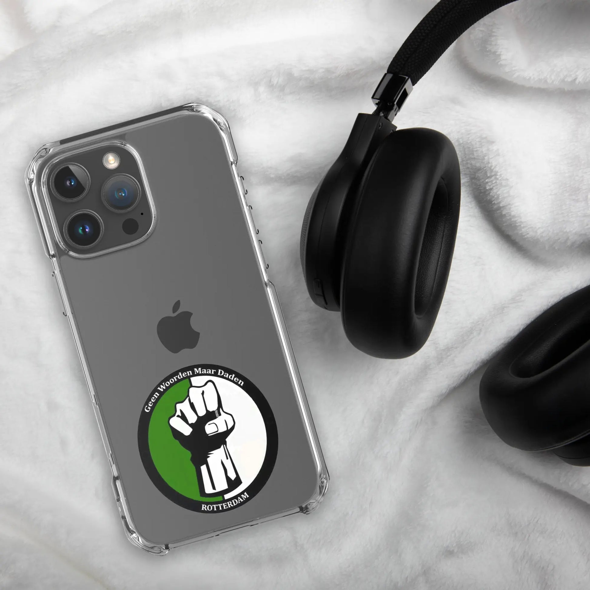 Feyenoord iPhone 16 hoesje met Geen Woorden Maar Daden logo, stijlvolle bescherming, weergegeven naast zwarte koptelefoon