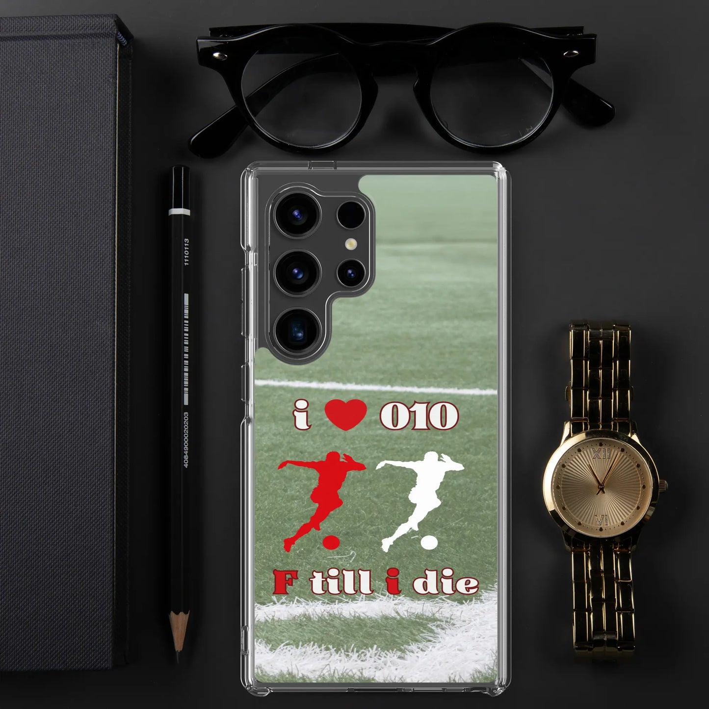 Feyenoord telefoonhoesje voor Samsung met I Love 010 en F Till I Die design, geplaatst op een zwarte achtergrond met bril, horloge en pen