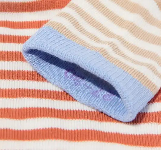 Close-up van HEMA gestreepte kindersok in oranje, beige en blauw, zachte katoenen textuur