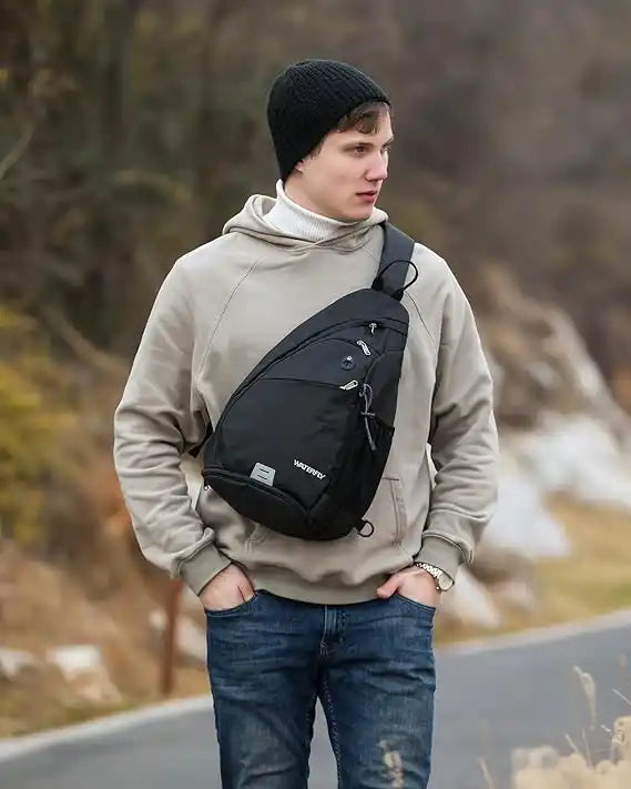 Man draagt zwarte sling rugzak, anti-diefstal crossbody tas voor outdoor en reizen.